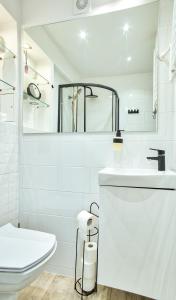 ein weißes Bad mit einem Waschbecken und einem WC in der Unterkunft Apartament Dla Dwojga in Sanok