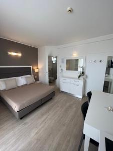 una grande camera da letto con un letto e un tavolo di Hotel Ardea a Riccione