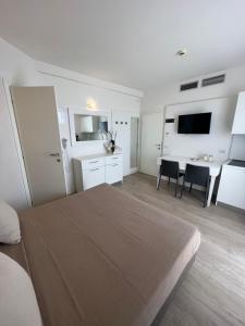 a bedroom with a bed and a kitchen and a table at Hotel Ardea in Riccione
