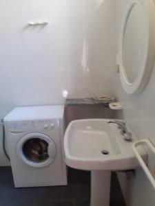 La salle de bains est pourvue d'un lave-linge et d'un lavabo. dans l'établissement Acquafredda House - Appartamento Primo Piano, à Acquafredda