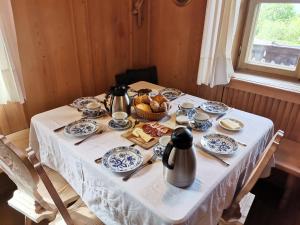 a table with blue and white dishes and a basket of food at Finhäusl - Urlaub bei Oma in Aldino