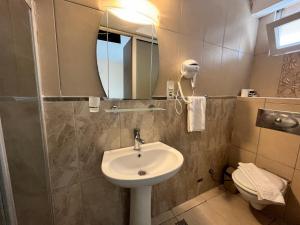 een badkamer met een wastafel, een spiegel en een toilet bij Romeo Beach Hotel in Kemer
