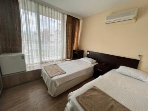 a hotel room with two beds and a window at Romeo Beach Hotel in Kemer