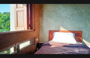 a small bedroom with a bed and a window at Baandindon Private Earthhouse Homestay in Mae Rim