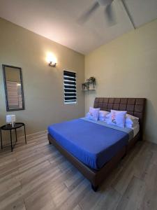 a bedroom with a large bed with blue sheets at Sunway Alpine Village near Onsen Lost World of Tambun Ipoh Ipoh city in Ipoh