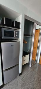 a kitchen with a microwave on top of a cabinet at Oasis Rentals, Diana Estate, Pattaya in Pattaya Central