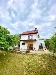 una pequeña casa blanca con techo rojo en BorászPorta - Présház en Villány