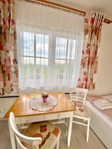 a dining room with a table and chairs and a window at BorászPorta - Présház in Villány +14 photos