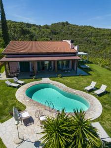 a villa with a swimming pool in front of a house at Fonte Murata B&B in Portoferraio