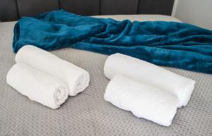 duas toalhas enroladas numa cama com um cobertor azul em Apartament Dla Dwojga em Sanok