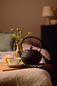 um bule de chá e uma chávena sobre uma mesa em Apartament Leszczyna em Olsztyn