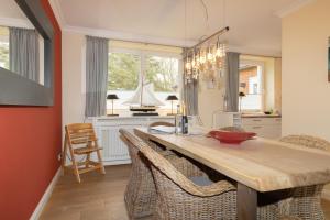 una cocina con una gran mesa de madera y sillas en Golfhouse I, en Hörnum