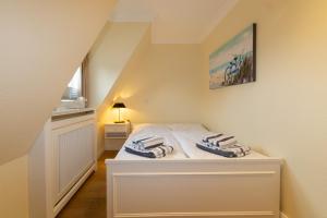 Dormitorio pequeño con cama en el ático en Golfhouse I, en Hörnum