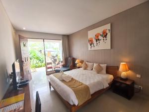 a bedroom with a bed and a television in it at Abian Harmony Hotel in Sanur