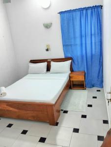 1 dormitorio con 1 cama con cortina azul en Chez Gero, en Cotonou