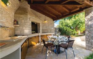 a kitchen with a table and chairs on a patio at Stunning Home In Sisan With Outdoor Swimming Pool in Šišan
