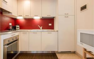 een keuken met witte kasten en een rode muur bij Awesome Apartment In Firenze With Wifi in Florence