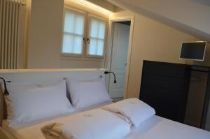 una camera con un letto con due cuscini bianchi di Casa Cristina a Cannobio