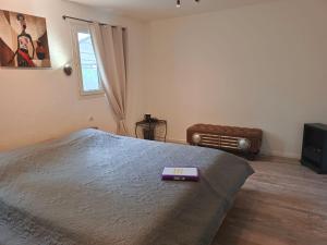 - une chambre avec un lit et un livre violet dans l'établissement NOTRE PETIT COIN DE PARADIS chambre privée chez l'habitant, à Seillons-Source-dʼArgens