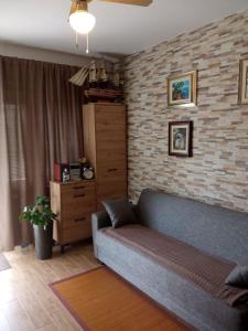 a living room with a couch and a brick wall at Sunce in Kostrena