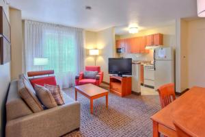 a living room with a couch and chairs and a kitchen at TownePlace Suites Raleigh Cary/Weston Parkway in Cary