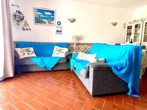 a living room with a blue couch and a chair at CasAzul in Olhão