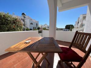 a wooden table and a chair on a balcony at CasAzul in Olhão