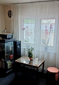 a living room with a table and two windows at Casă particulară in Suceava