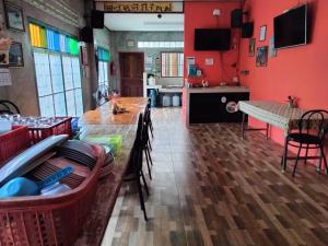 ein Esszimmer mit roten Wänden sowie einem Tisch und Stühlen in der Unterkunft เรือนแรก โฮมสเตย์ in Ban Tha Sao