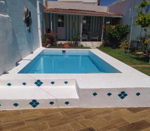 una piscina de agua azul y un baño blanco en Casa con piscina cerca de Sevilla, en Carrión de los Céspedes