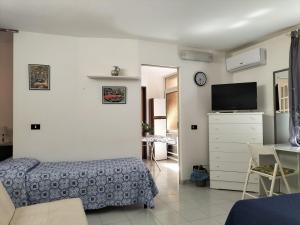 a bedroom with a bed and a dresser with a tv at Home Vivaldi in Castellammare del Golfo