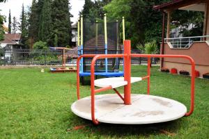 a playground in a yard with a swing at Vila Marija - Teo in Star Dojran