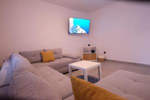 ein Wohnzimmer mit einem Sofa und einem TV an der Wand in der Unterkunft Krasa Escape in Novi Vinodolski