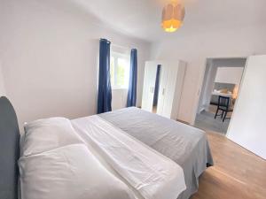 a bedroom with a large white bed with blue curtains at Krasa Escape in Novi Vinodolski +6 photos