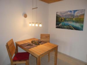 einen Esstisch und Stühle mit einem Gemälde an der Wand in der Unterkunft Ferienwohnung Moritz in Oy-Mittelberg