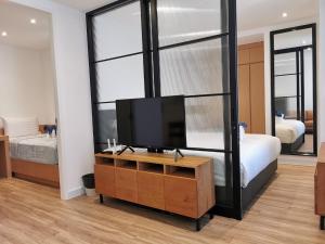 a bedroom with a tv on a dresser and a bed at Tay Residence in Bangkok