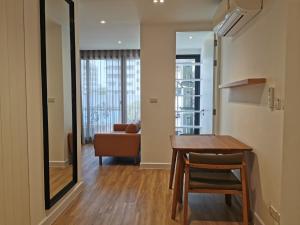 a dining room with a table and a couch at Tay Residence in Bangkok