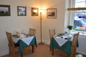 a dining room with two tables and a lamp at Beckside Guest House Keswick in Keswick