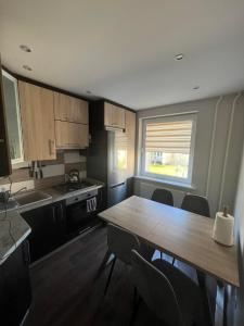 een keuken met een tafel en stoelen en een raam bij LUNA Apartamentai in Akmenė