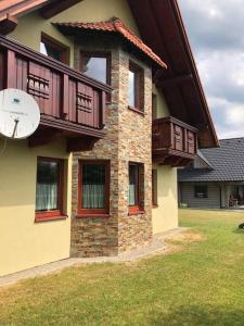 a house with a clock on the side of it at chata ORAVSKA priehrada in Námestovo