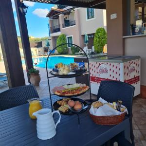 a blue table with breakfast foods on it at Gianna Apartments in Almirida