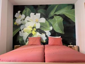 マラガにあるApartamento La Biznagaの花の絵が飾られた部屋の赤いベッド2台