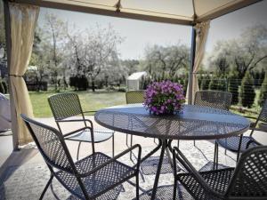 einen Tisch und Stühle auf einer Terrasse mit lila Blumen in der Unterkunft Sunny family terrace in Riga