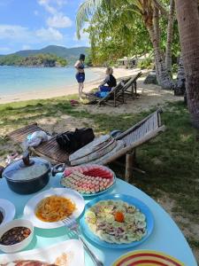 a table with plates of food on the beach at NATUA'S BEACH RESORT in Liminangcong