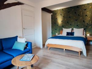 ソリュにあるLes Suites - Saulieuのベッドルーム(ベッド1台、青いソファ付)