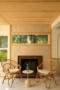 two chairs and a table in front of a fireplace at Hotel des Dunes in Cap-Ferret
