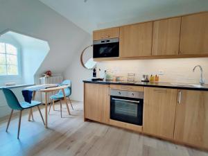 ソリュにあるLes Suites - Saulieuのキッチン(木製キャビネット、テーブル、椅子付)