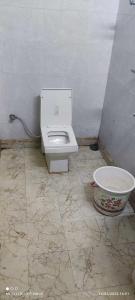a bathroom with a toilet and a bowl on the floor at OYO Gupta Guest House in Morādābād
