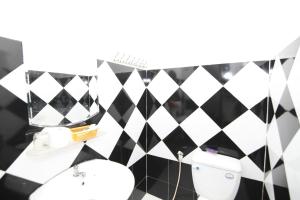 a bathroom with a black and white tiled wall at KHÁCH SẠN SAO MAI in Ho Chi Minh City