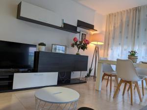 a living room with a television and a table and chairs at Oliva Moon in Oliva